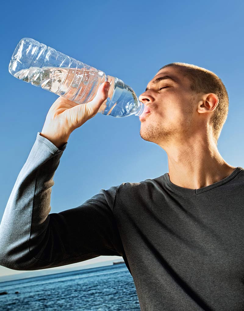person drinking from water bottle