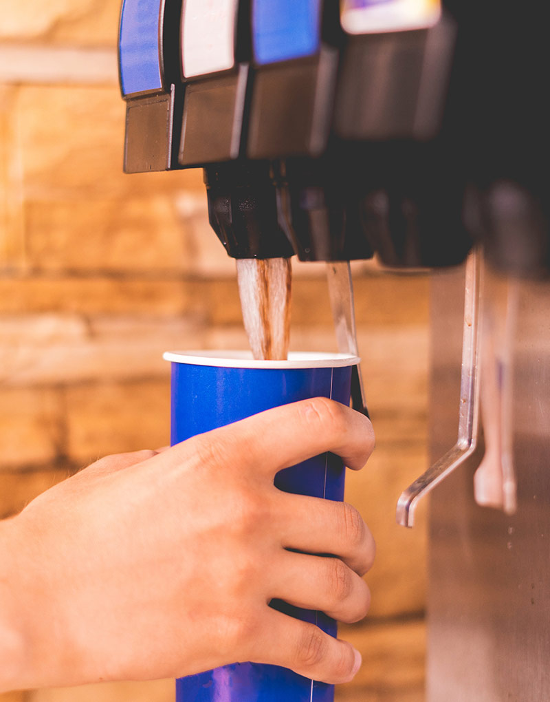 person dispensing soft drinks out of a pepsi midamerica fountain soda machine