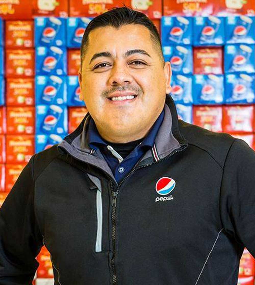 Pepsi Employee posing for photograph in front of product